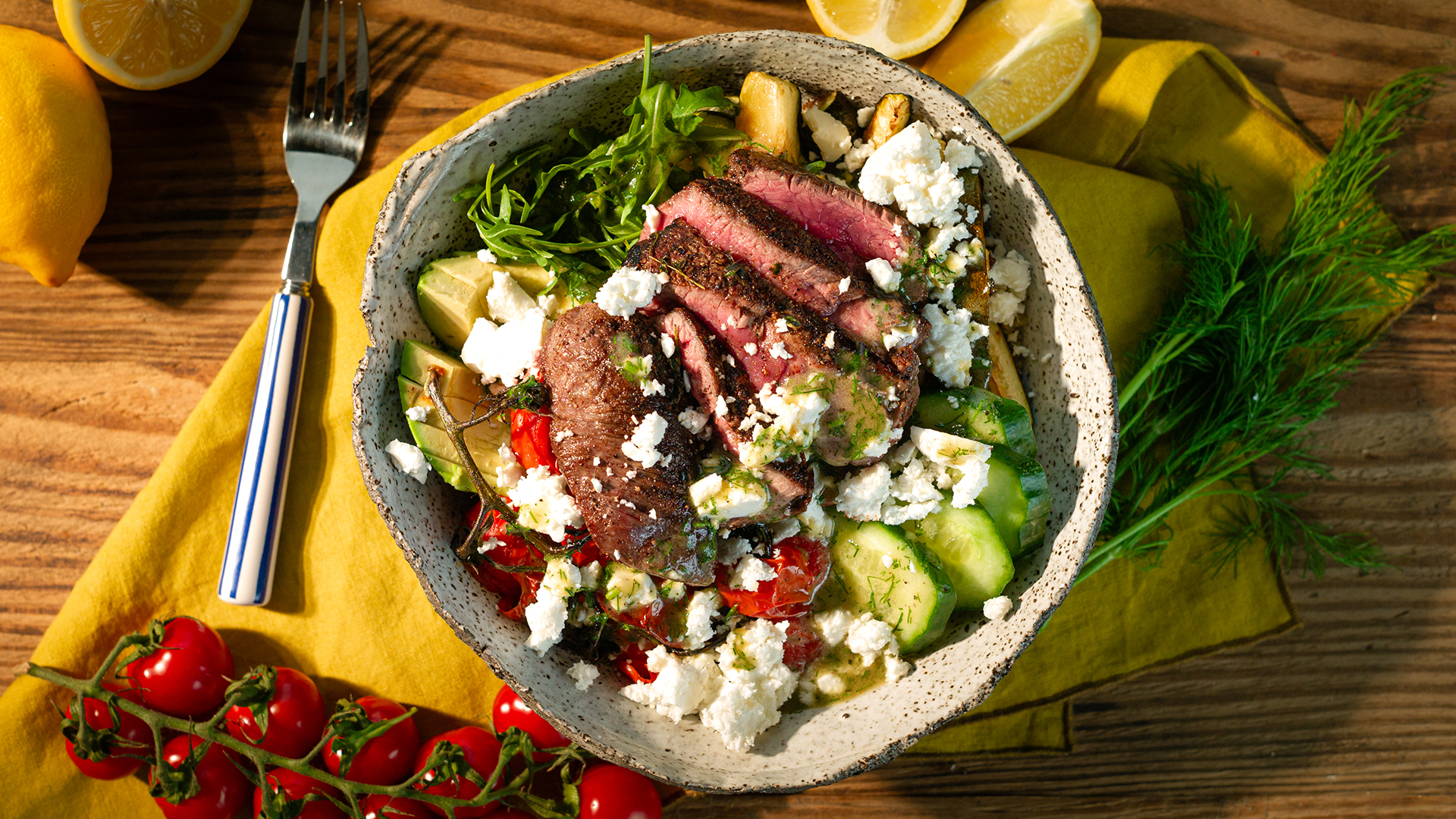 Bowl ze stekiem, grillowaną cukinią, awokado, ogórkiem, pieczonymi pomidorami i fetą